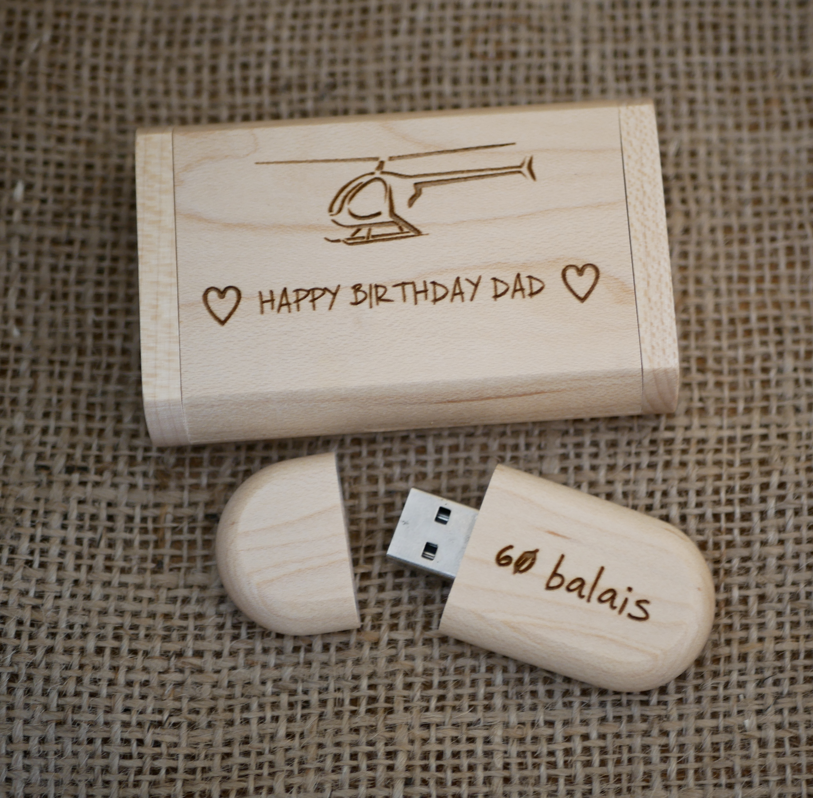 Gravure van een helikopter op een USB-stick van licht hout