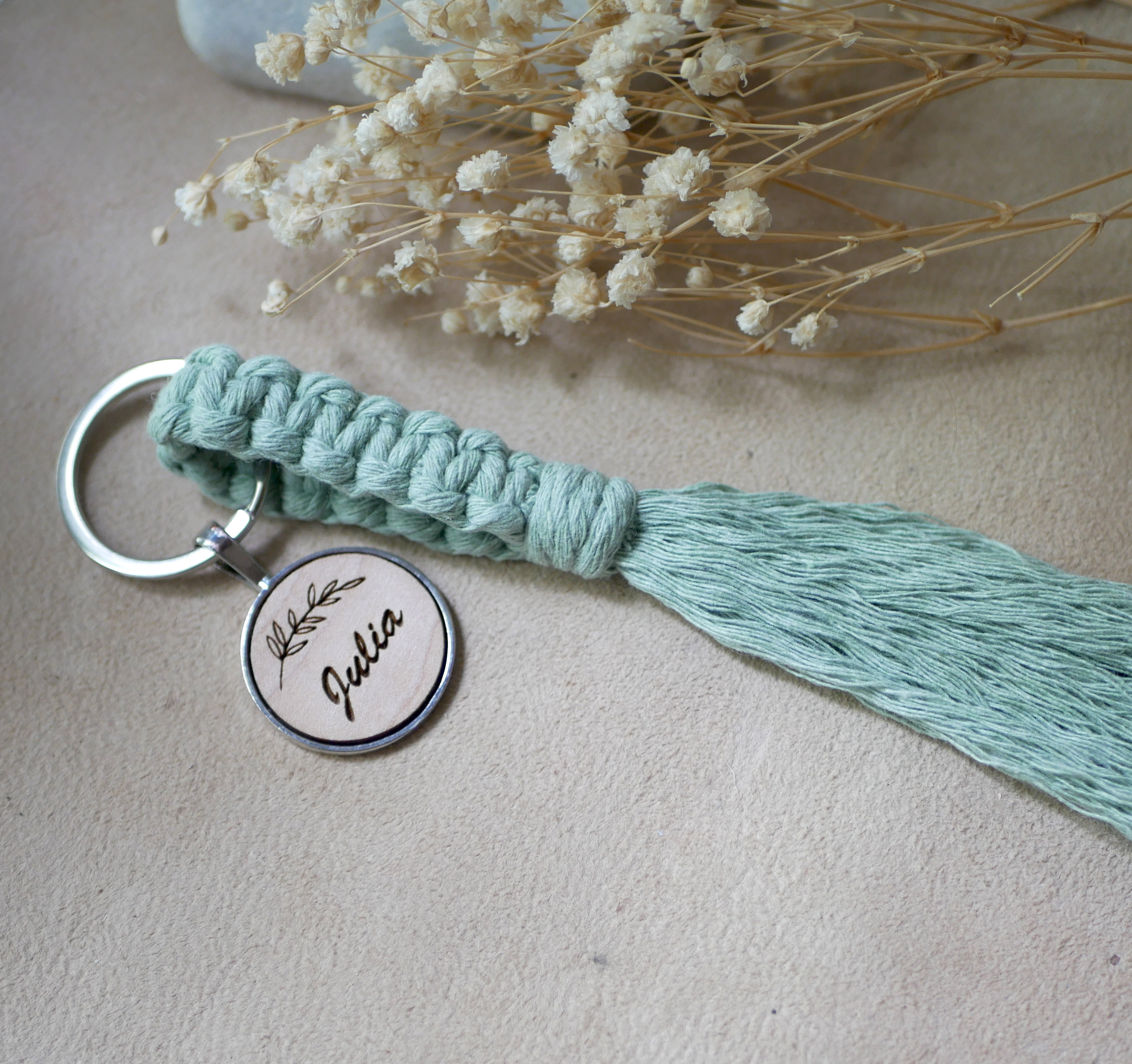 Sleutelhanger met gepersonaliseerde houten cabochon en macraméversiering in verschillende kleuren 