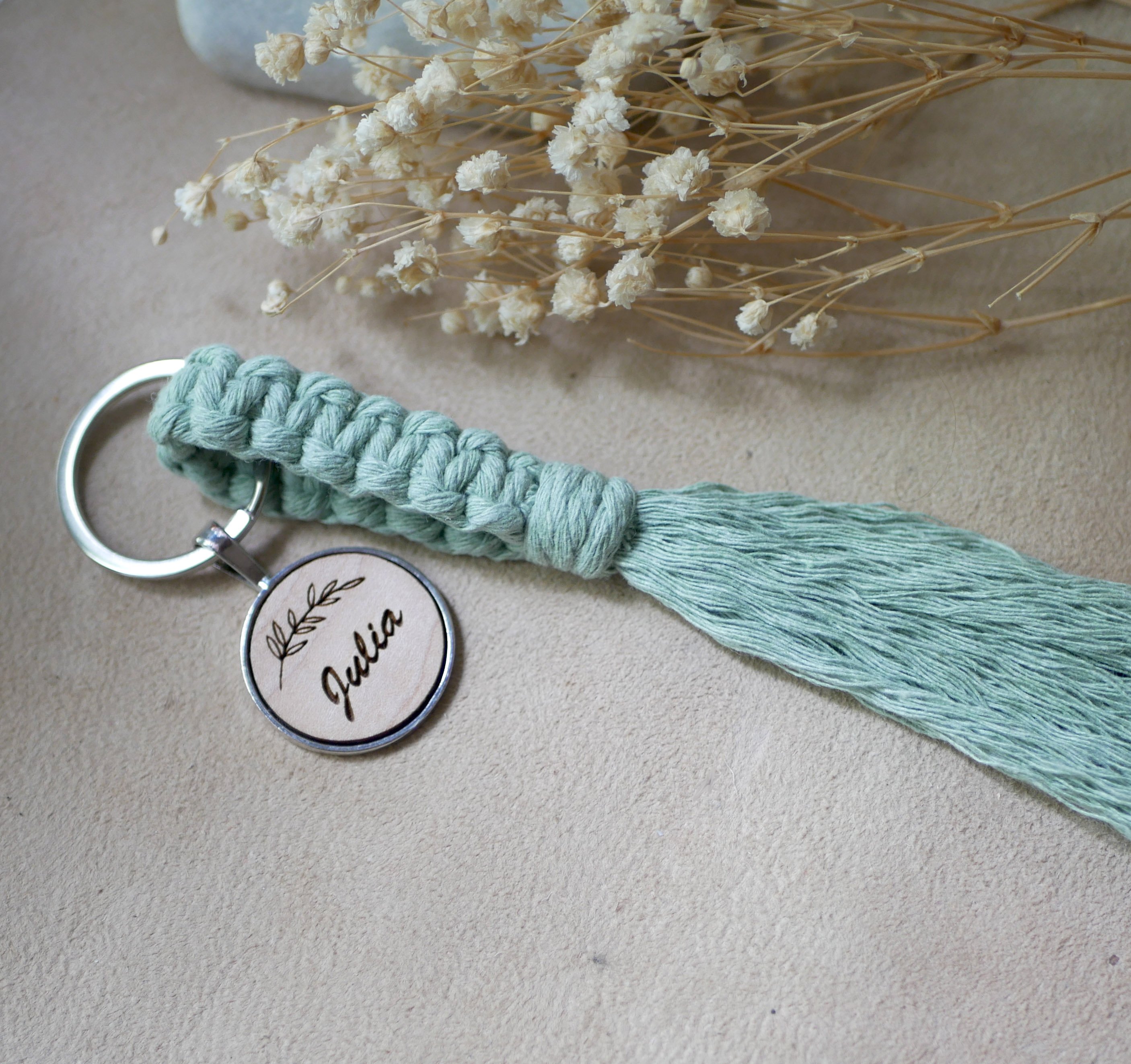 Sleutelhanger met gepersonaliseerde houten cabochon en macraméversiering in verschillende kleuren 