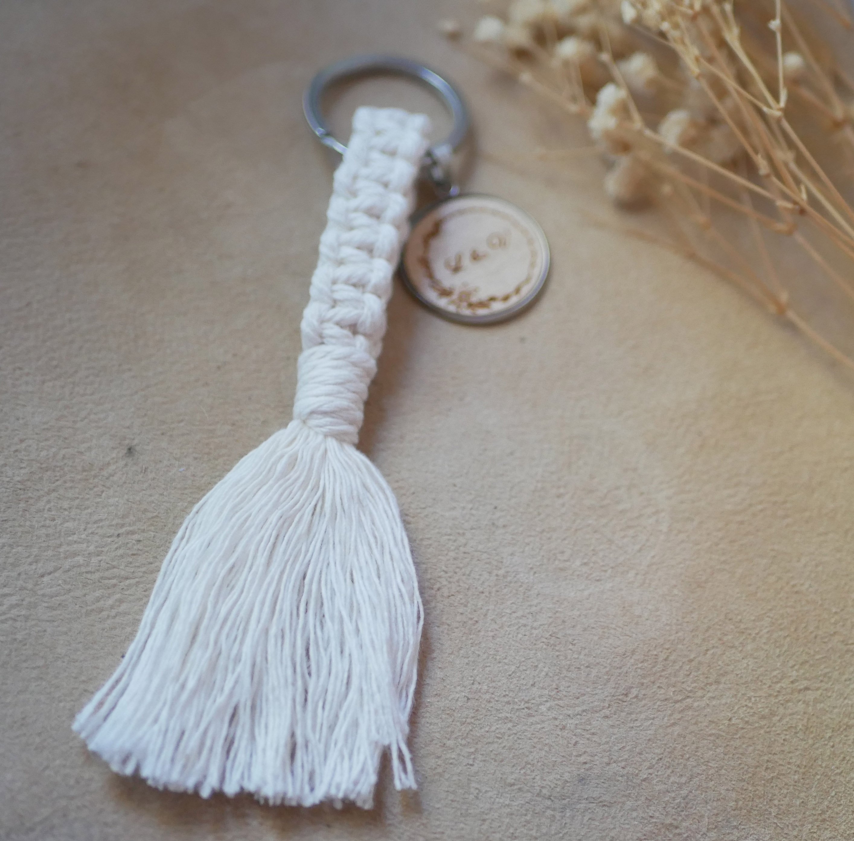 Sleutelhanger met gepersonaliseerde houten cabochon en macram&eacute;versiering in verschillende kleuren 