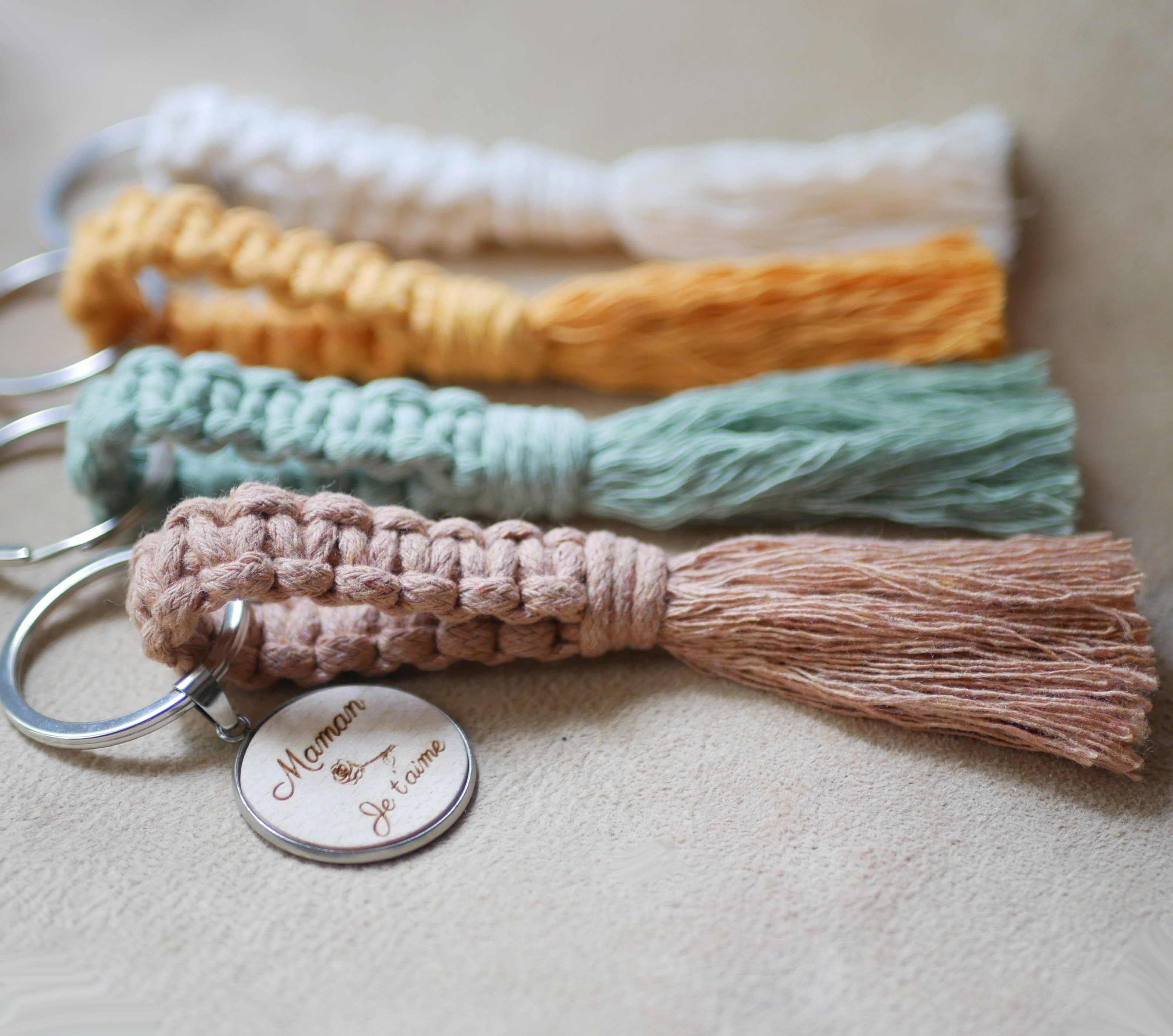 Sleutelhanger met gepersonaliseerde houten cabochon en macraméversiering in verschillende kleuren 