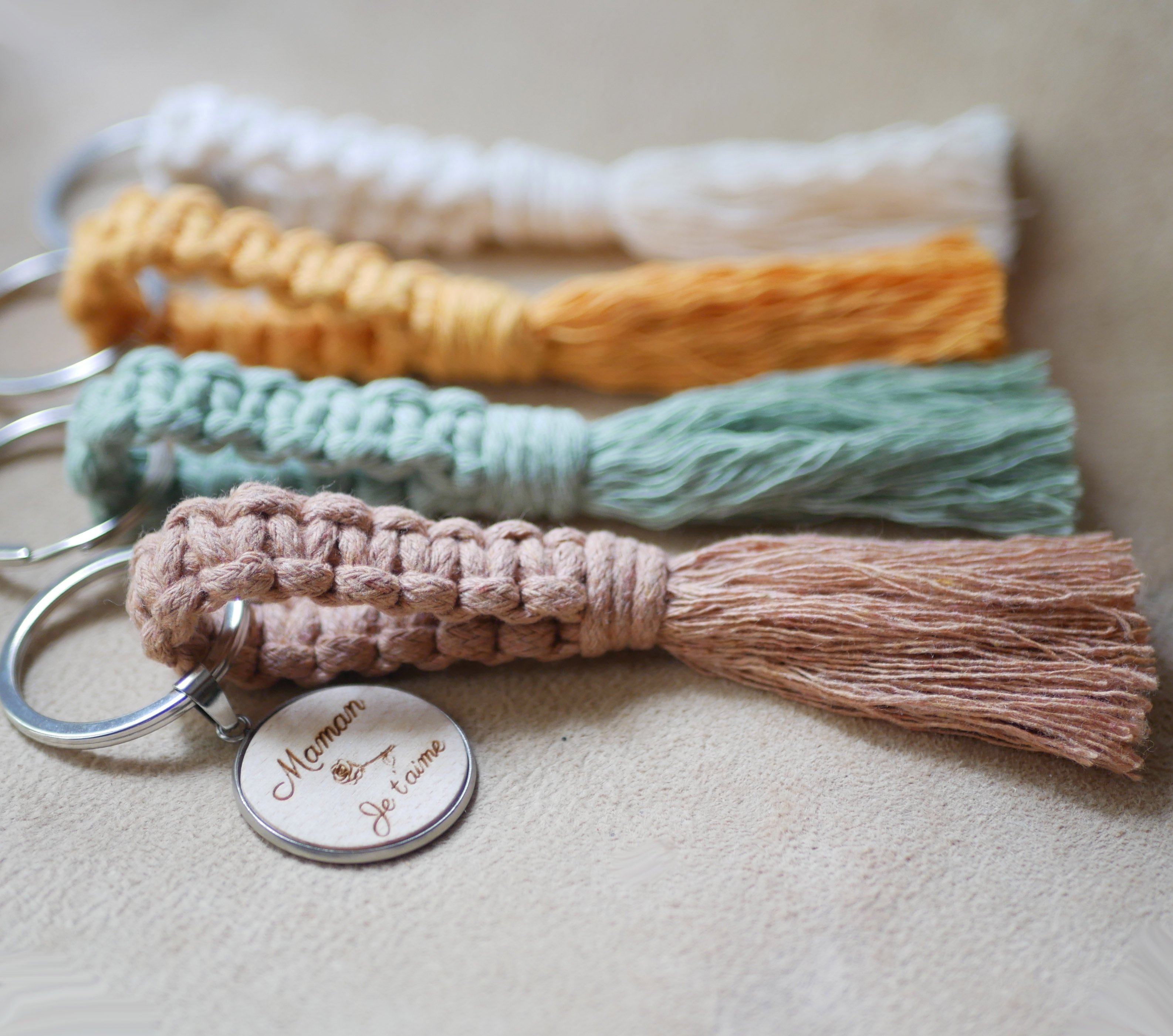 Sleutelhanger met gepersonaliseerde houten cabochon en macraméversiering in verschillende kleuren 